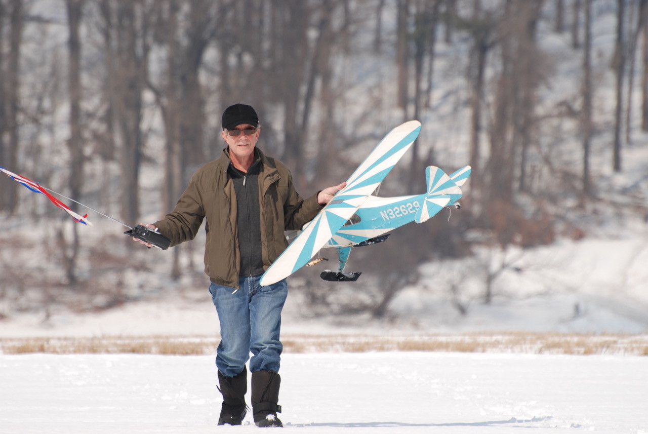 RC airplane flying in snow on skis